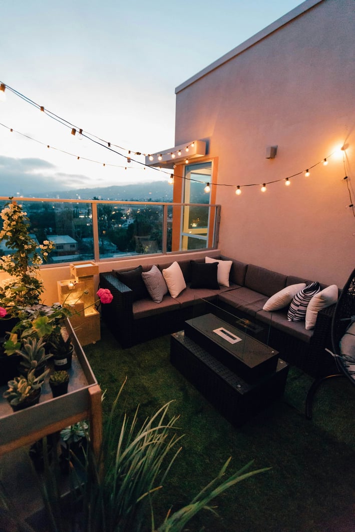 a couch with pillows and a table with a table with a plant
