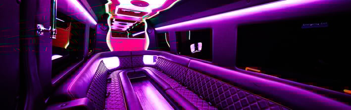 The inside of a party bus limo with pink neon