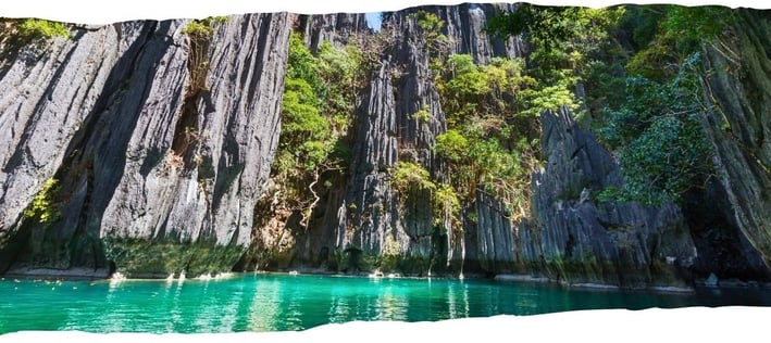 Foto de fundo da página em passeio de barco por Palawan, Filipinas, entre águas cristalinas e formações rochosas.