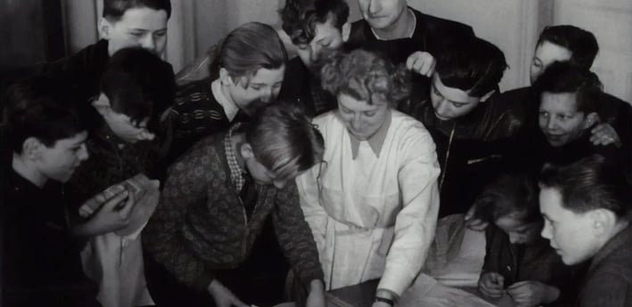 a group of people standing around a table
