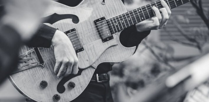 a black and white photo of a man playing guitar 