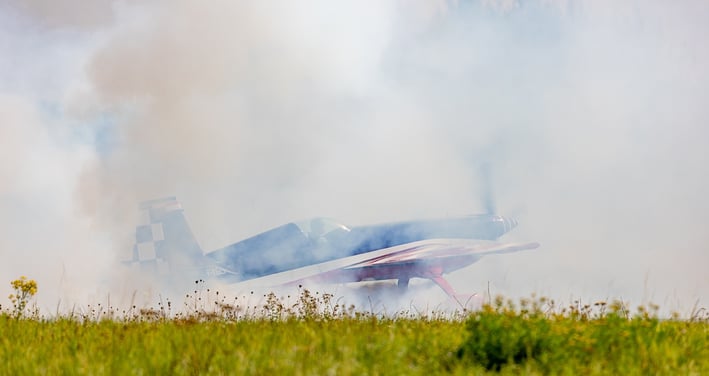 a plane is flying low over a grassy area