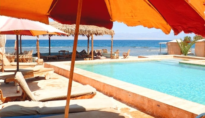 Beach pool with lounge chairs and umbrellas