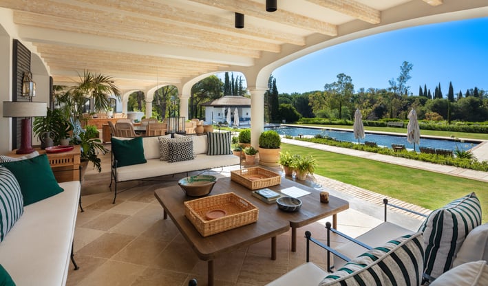 View from the shaded porch across the pool and gardens of Villa La Gratitud