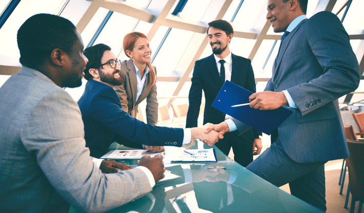 a man and woman shaking hands in a meeting room