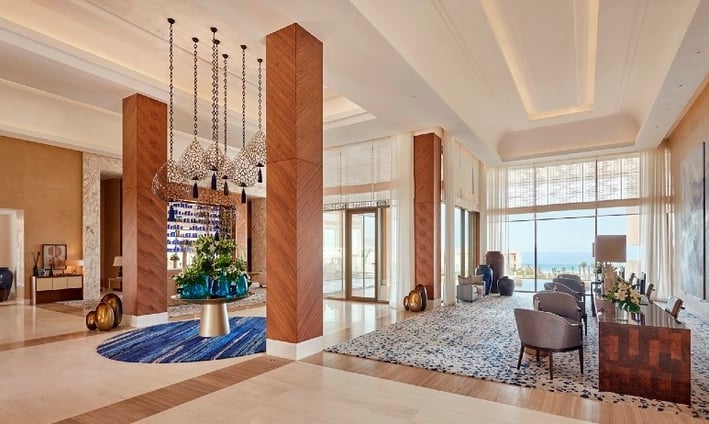 Ocean-inspired mural bespoke art by Lumai Studio anchoring reception interior at Fairmont Taghazout 