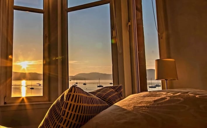 The bed at Gourock Seaview Holiday Let with a view of the sun setting over the water
