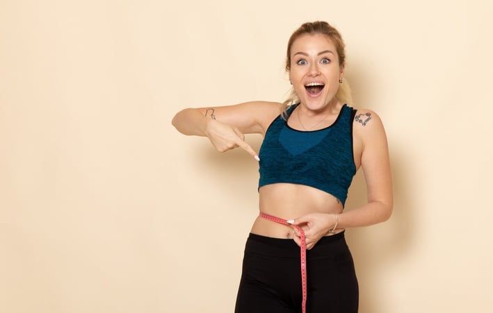 front-view-young-female-sport-outfit-measuring-her-sizes-waist_140725-85472