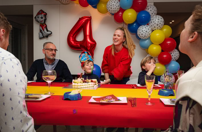a family celebrating a birthday party with a birthday cake