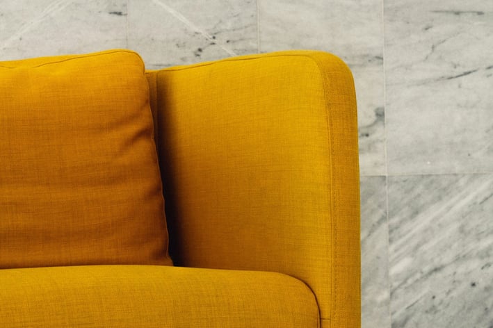 a couch with a yellow couch in a room