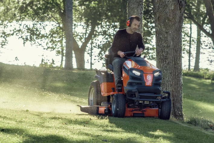a man riding on a lawn mower with a lawn mower