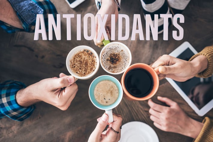 a group of people holding coffee cups with the words antioxidants
