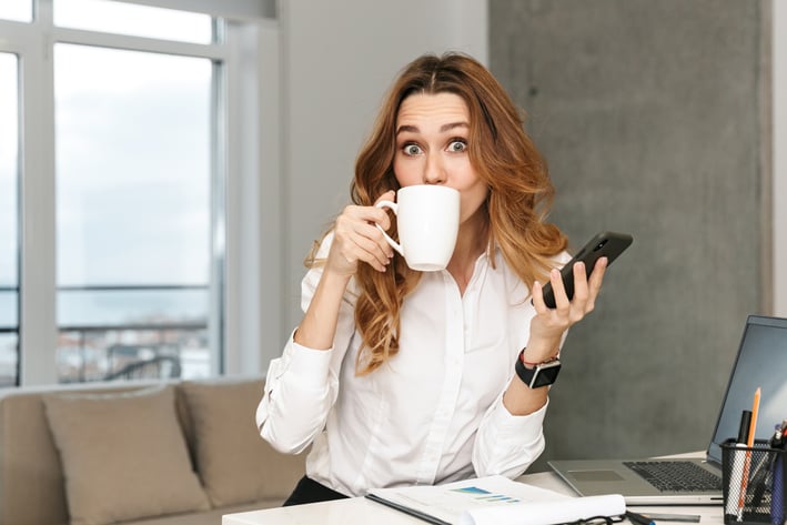 a woman sitting at a desk with a cup of coffee