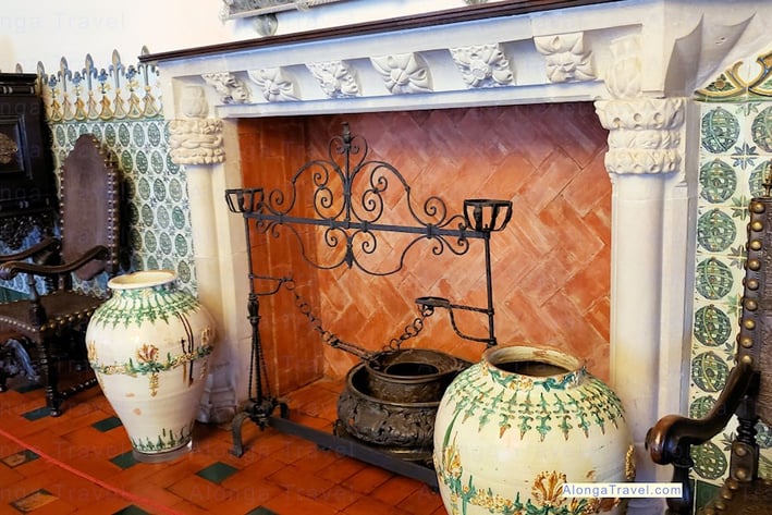 an ornately decorated brick and plaster Mudejar fireplace surrounded by Moorish ceramic tiles