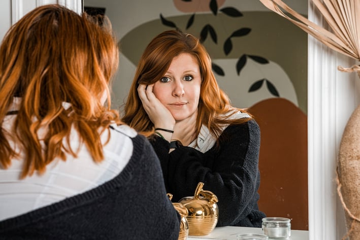Portrait d'une femme rousse reflétée dans un miroir