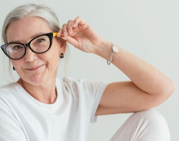 a woman with glasses and a white shirt