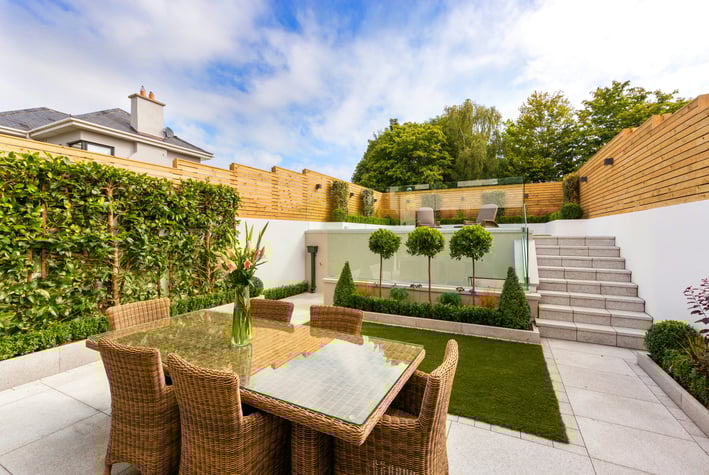 a patio with a table and chairs and stairs