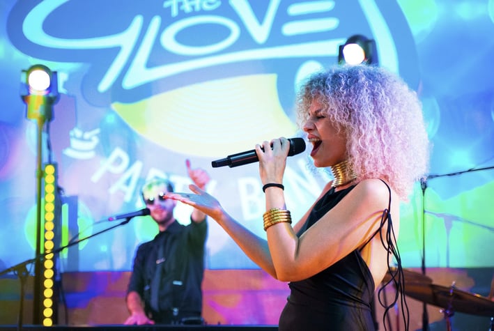 Wedding singer performing live with The Gloves logo in the background