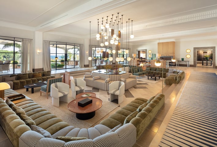Grand salon at Villa La Gratitud with designer sofas, statement chandelier, and garden views through