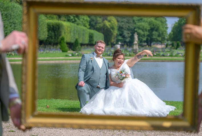 Un couple heureux prit en photo à travers un cadre de tableau