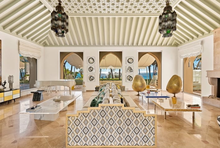 Living room at Villa El Rincon in Marbella featuring sea views, elegant décor, and floor-to-ceiling windows.