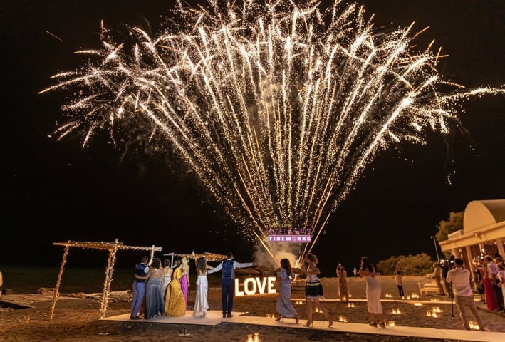 Dazzling Santorini fireworks illuminating a romantic wedding night sky.