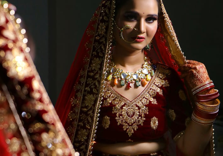 a woman in a red and gold bridalle dress