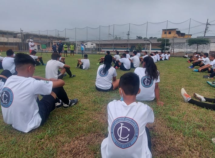 a group of young men and women sitting on a field