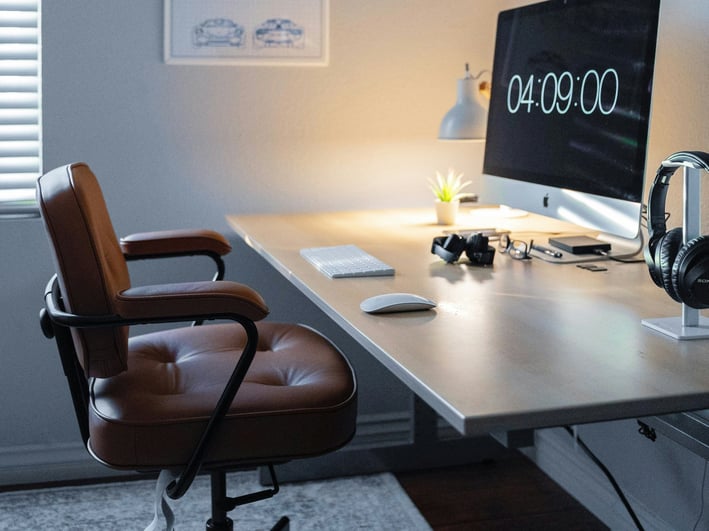 a desk with a computer monitor and a desk with a clock