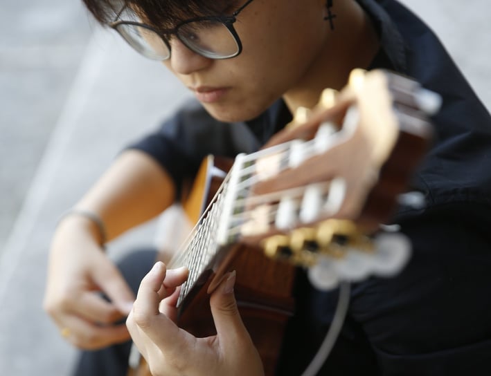 a woman with glasses and a guitar in her hands