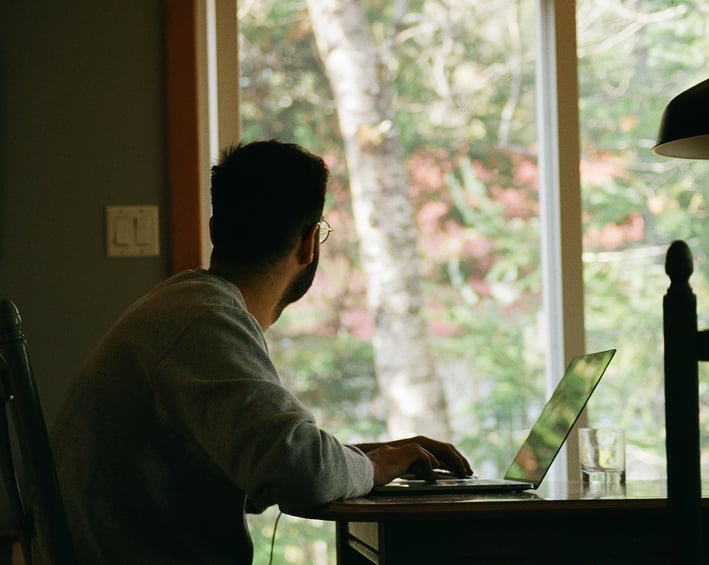 a man sitting at a table with a laptop computer