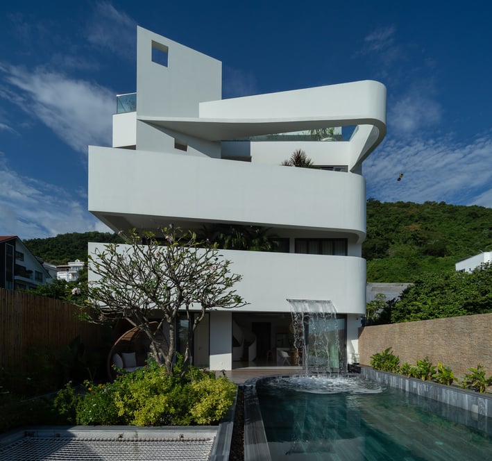 a house with a waterfall in the middle of the pool