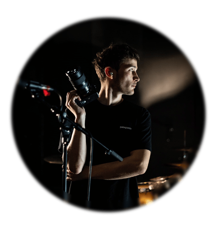 Portrait d’un photographe en concert, appareil en main, capturé en lumière de scène