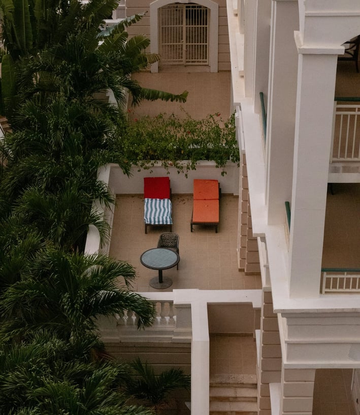 a balcony with a table and chairs in the middle of the room