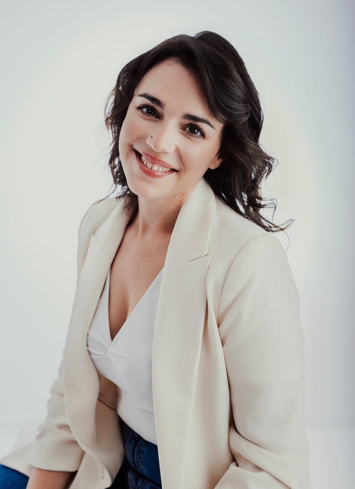 a woman in a white shirt and jeans sitting on a chair