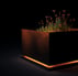a planter with flowers in a black box
