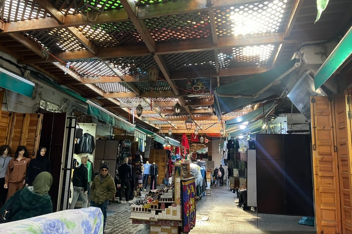 a man standing in a market place with a lot of people