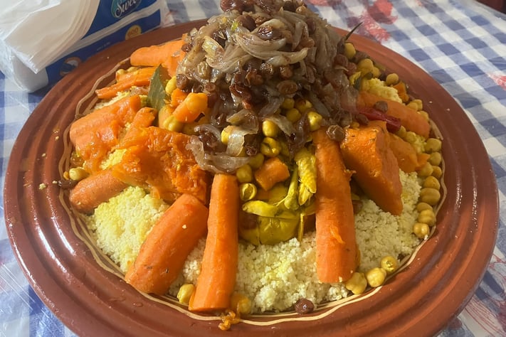 a plate of couscous with carrots and vegetables