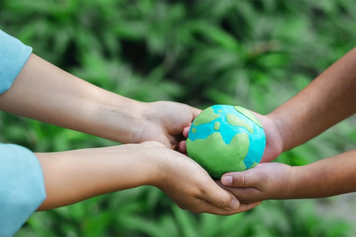 2 kinderen die een wereldbol vasthouden en milieuvriendelijkheid uitbeelden