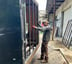 a man standing next to a trailer frame door