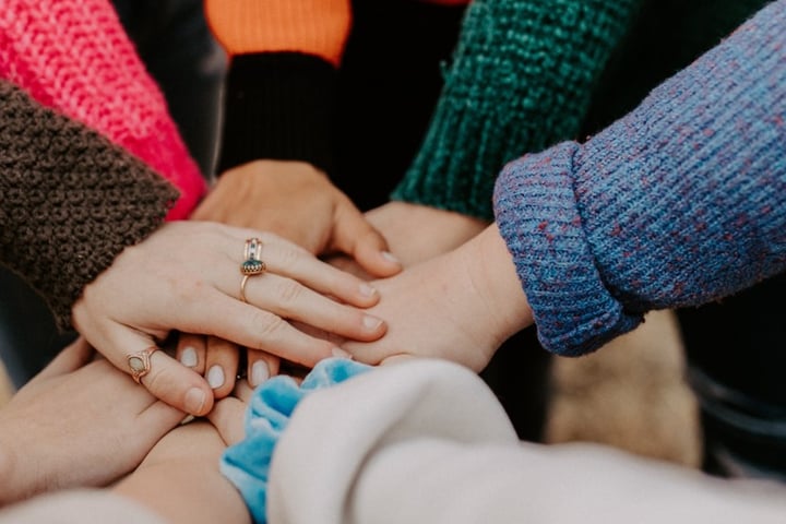 a team of people holding hands together in solidarity