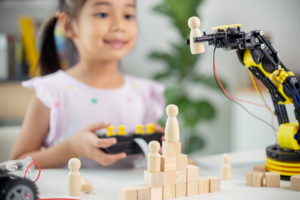A young girl joyfully explores a robot STEM toy, enhancing her creativity and engineering skills.