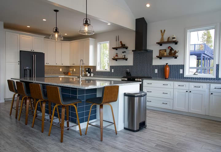 A kitchen with a large island and a bar stool