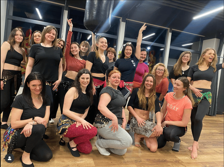 A big smiling group of Aleksandra's belly dance students after class
