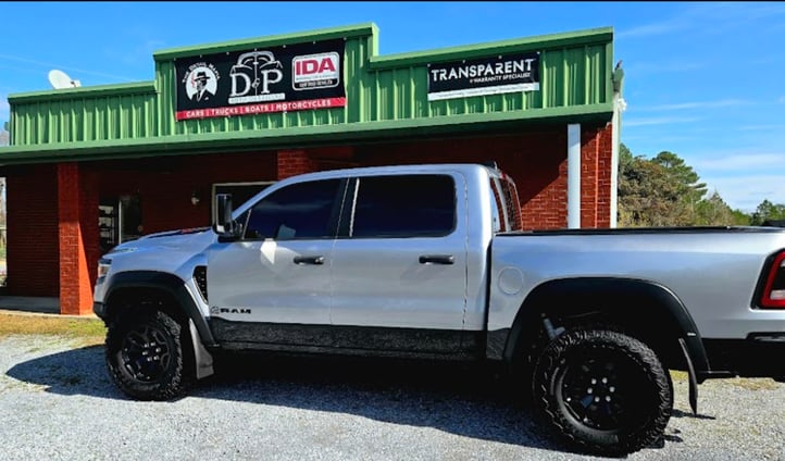 A truck, tinted in front of D and P auto detailing