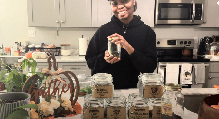 a woman in a black hoodie and a jar of tea
