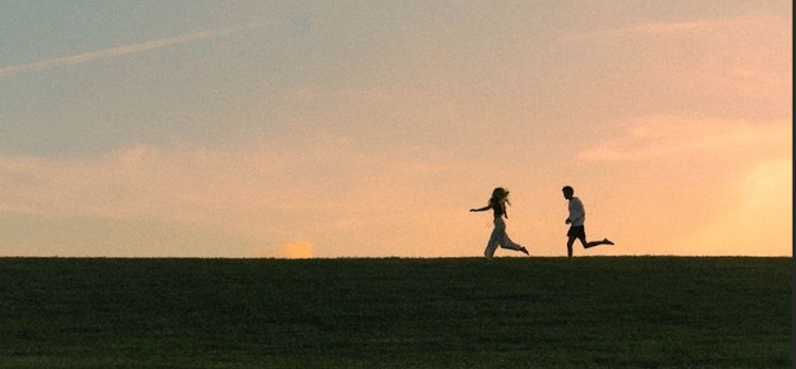 Spratt, A. (t.y.). Silhouette of two people running on a hill at sunset. Unsplash.