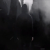 Dark cinematic shot - zoomed out man in black hoodie under urban city