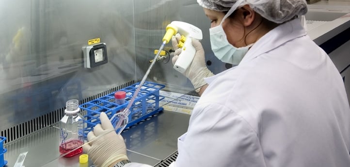 a woman in a lab coat and gloves is holding a pipe and a pipe