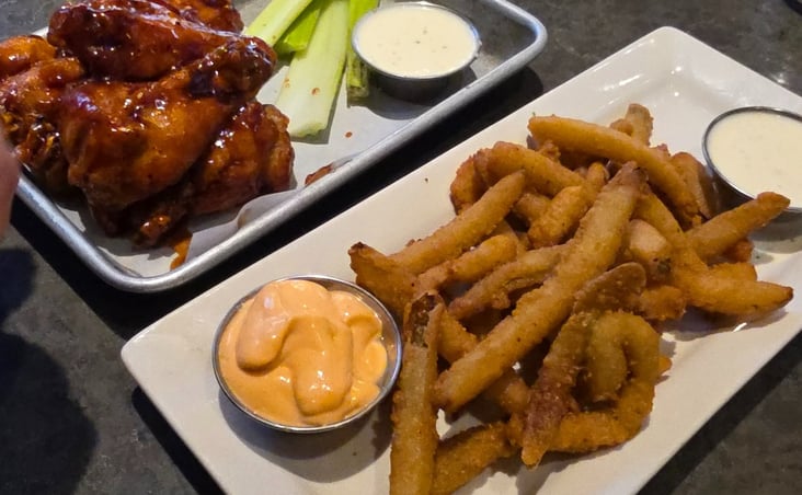 plate of Fryckle fries, ranch, barbeque wings, and celery